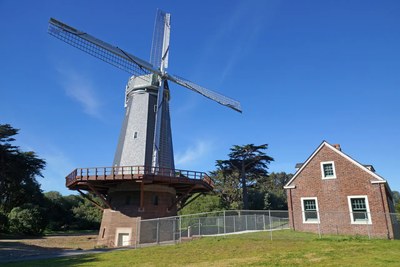 The Murphy Windmill and a red brick cottage beside a lawn at the southwest corner of the park