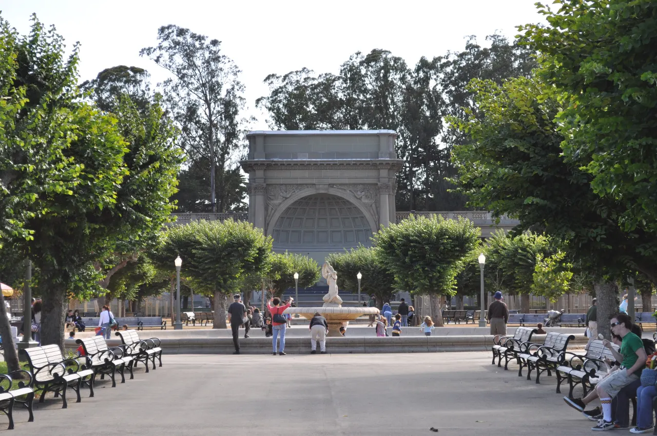 The Spreckels Temple of Music bandshell with benches and trees on the Music Concourse