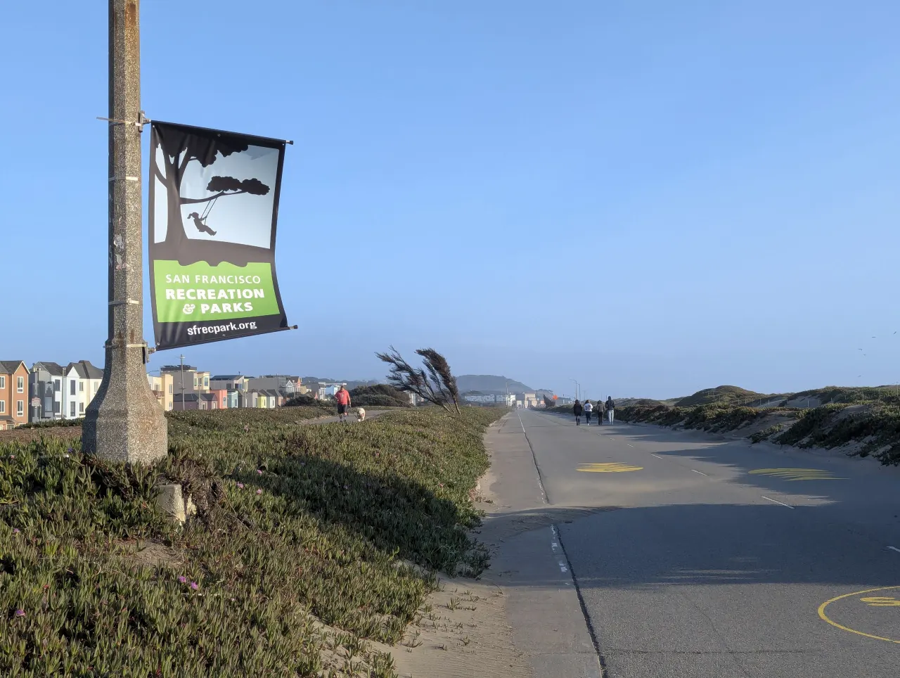 A car-free former highway with a park sign beside the dunes at Sunset Dunes